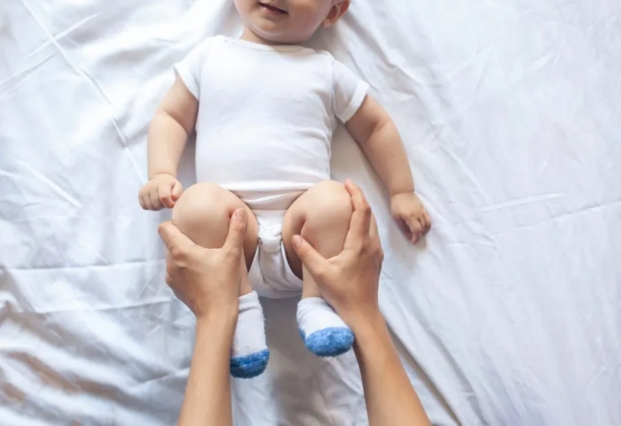 Bạn có thể thực hiện co duỗi hai chân của trẻ theo nhịp chậm, giúp hỗ trợ quá trình đi ngoài